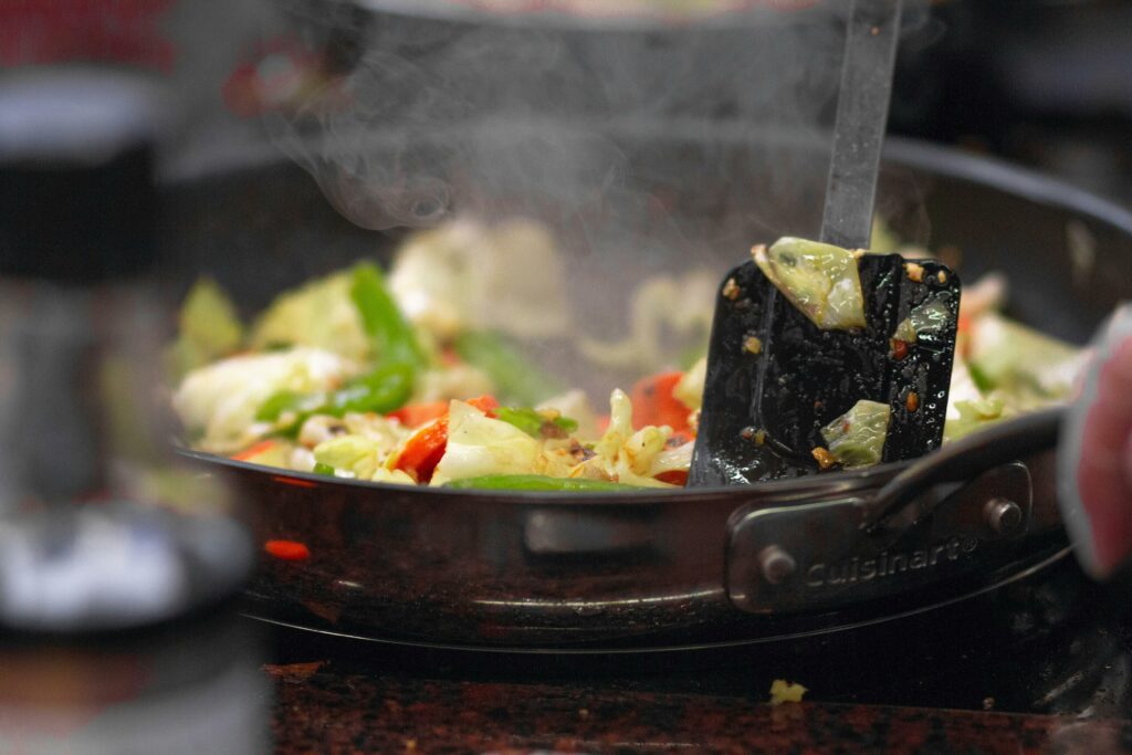 pexels-photo-1040685-1040685 A vibrant stir fry of fresh vegetables sizzling in a pan, releasing steam.