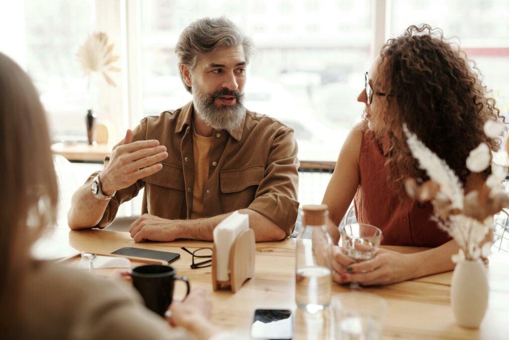 pexels-photo-4347481-4347481 A friendly discussion among colleagues in a cozy cafe environment, fostering teamwork and collaboration.
